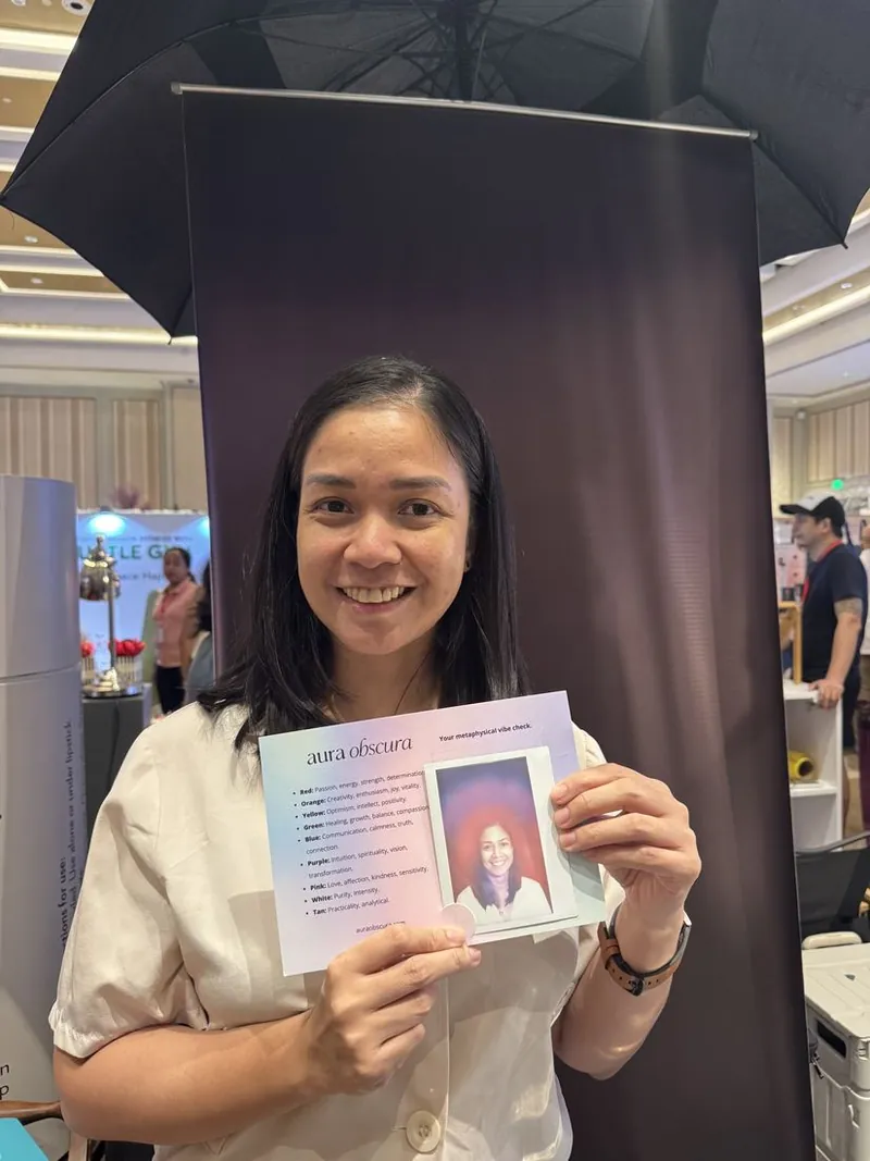 guest smiling with her aura portrait at the pop-up