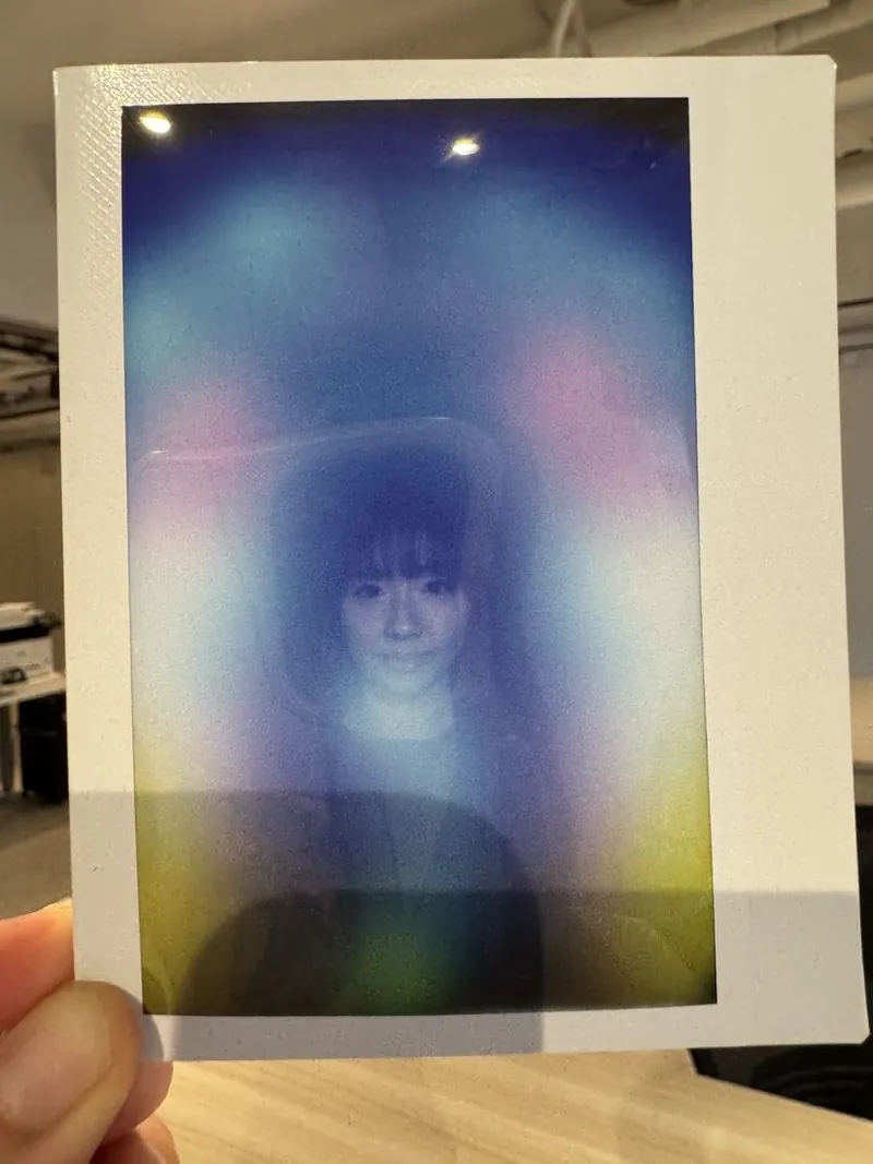 an aura print fresh from the camera, held up